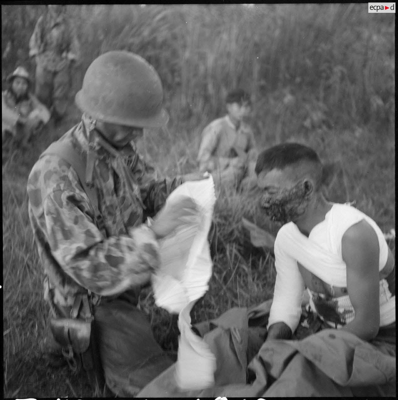 Un parachutiste panse un bless&eacute; avant son &eacute;vacuation &agrave; l'antenne chirurgicale de Na San.