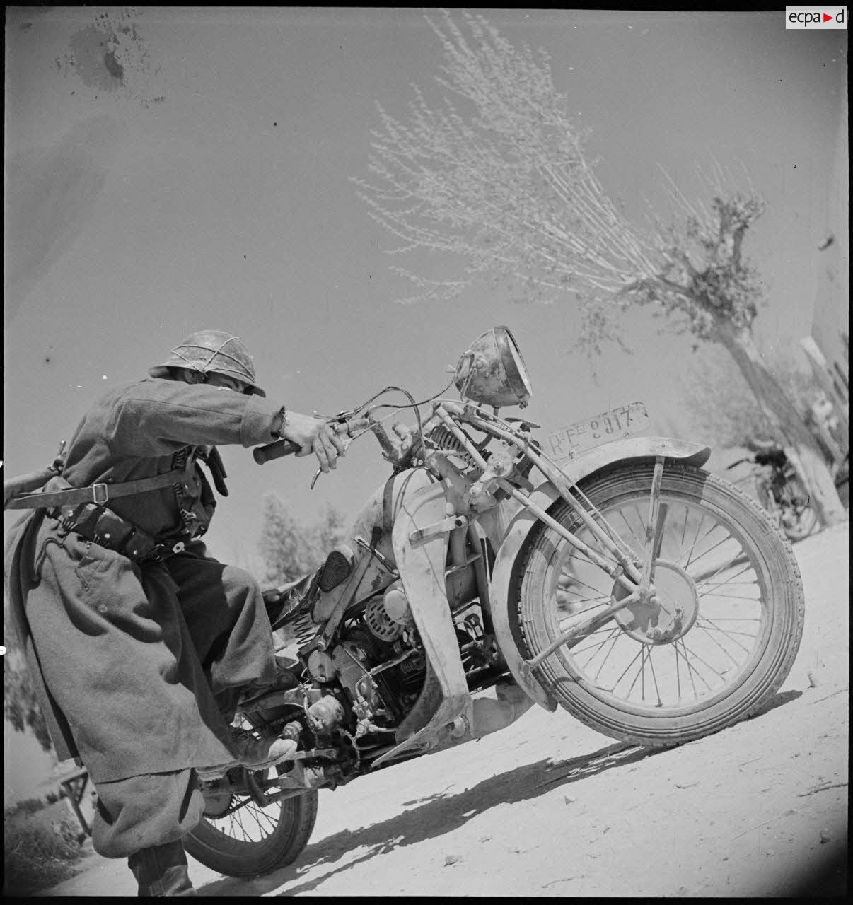 Un goumier du IIe Tabor du 1er GTM (groupe de tabors marocains) de la 1re DMM (division de marche du Maroc) démarre une Moto-Guzzi GT17 prise à l'armée italienne, dans le secteur de Siliana.