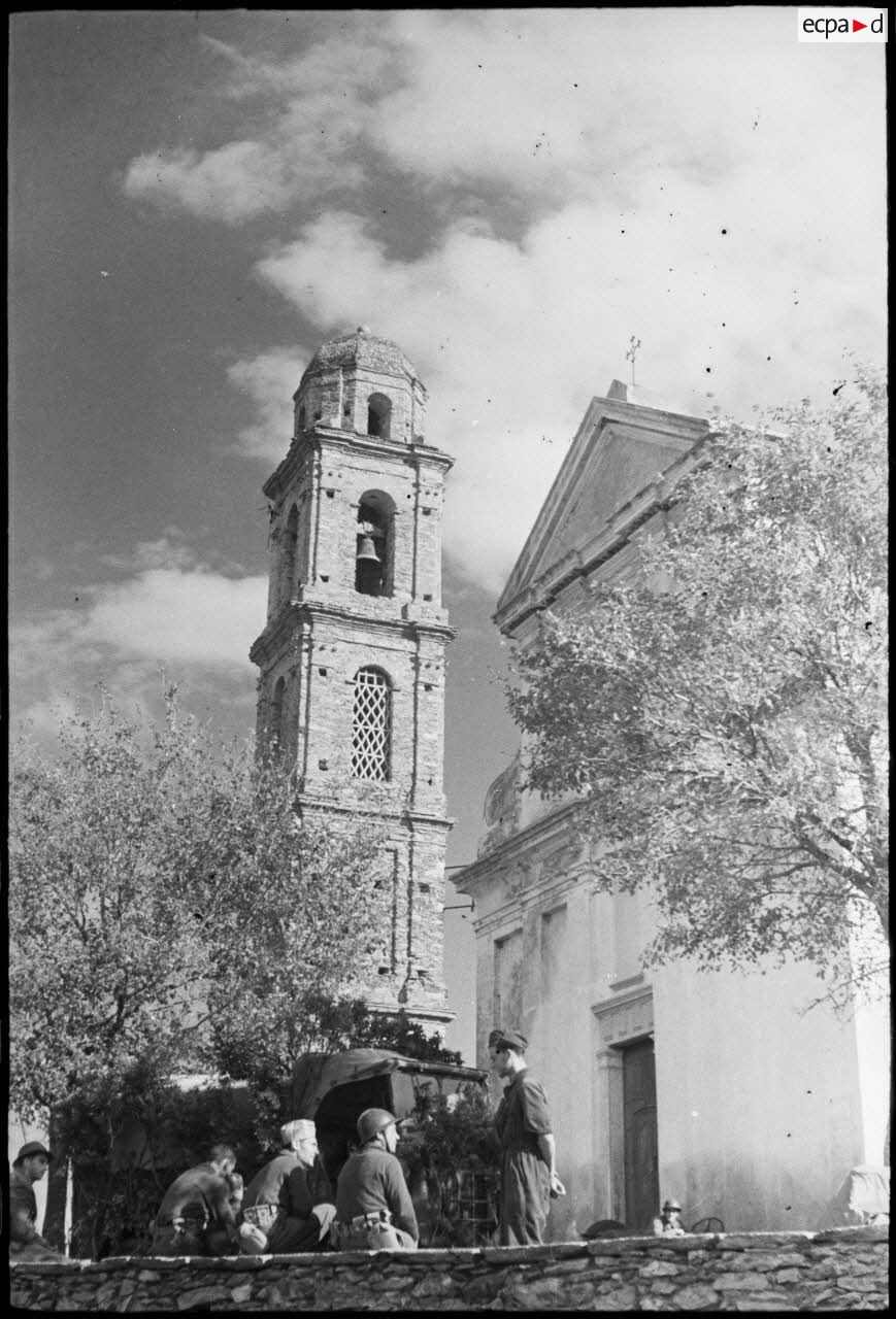 Des tirailleurs du 1er RTM (régiment de tirailleurs marocains) discutent devant l'église du village de Piève.