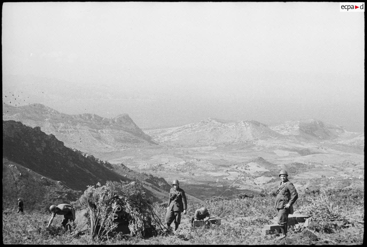 Des fantassins de la division italienne Friuli, servants d’un obusier de 75 mm camouflé, sont en position au col de Teghime, en appui des troupes françaises.