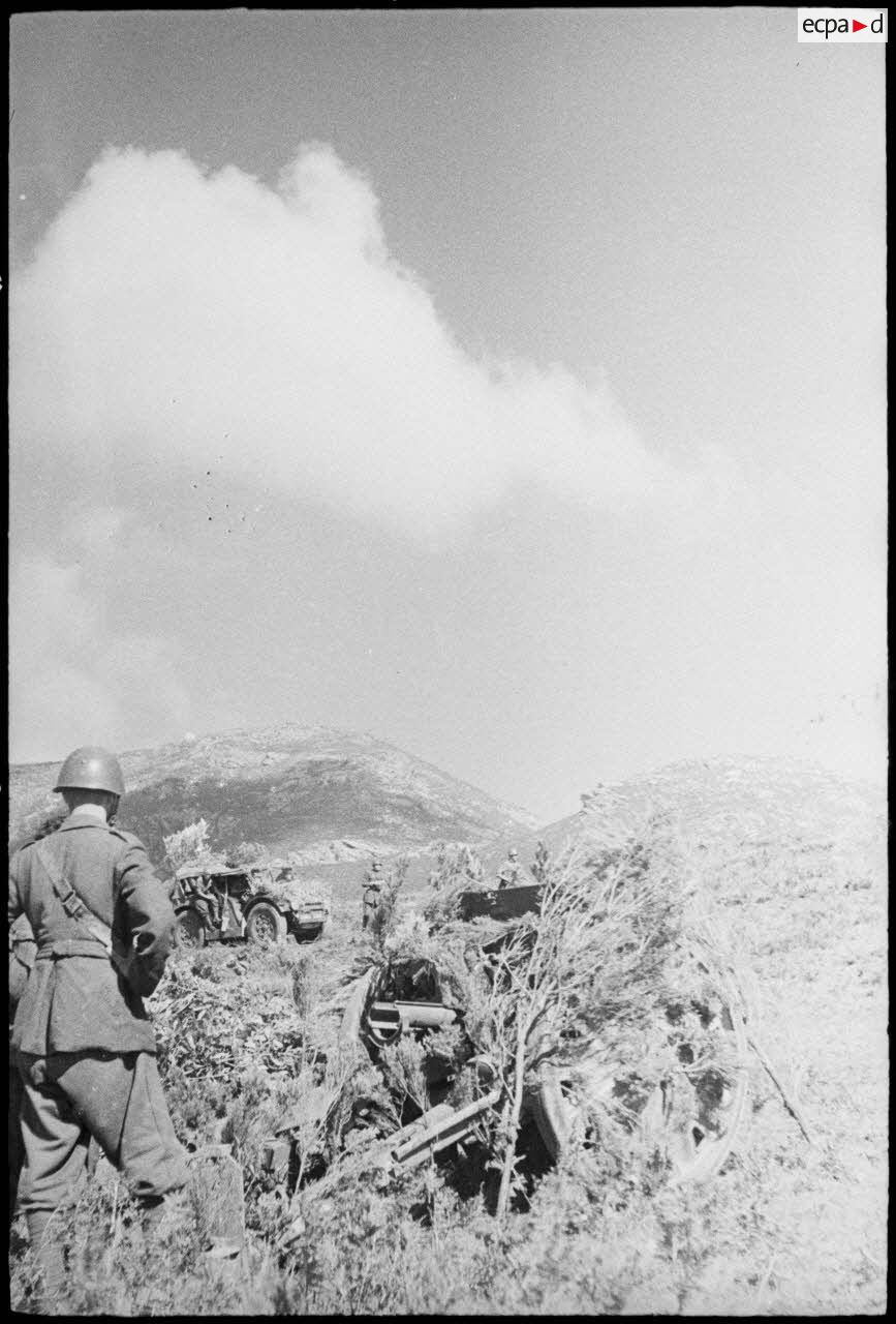 Des obusiers camouflés (de 75/18 modèle 35) et des servants de la 20e division d'infanterie italienne Friuli sont en position au col de Teghime, en appui des troupes françaises. Il s'agit probablement d'une pièce d'artillerie appartenant à un groupe du 35e régiment d'infanterie.