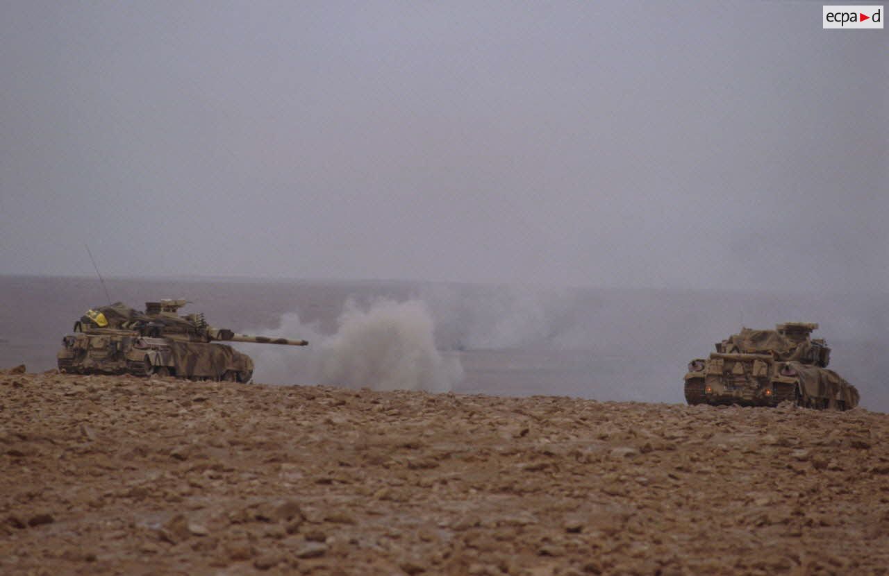 Deux chars lourds de combat AMX-30 B2 du 4e RD (régiment de dragons) progressent au-delà de la frontière irakienne; celui de gauche vient de tirer.