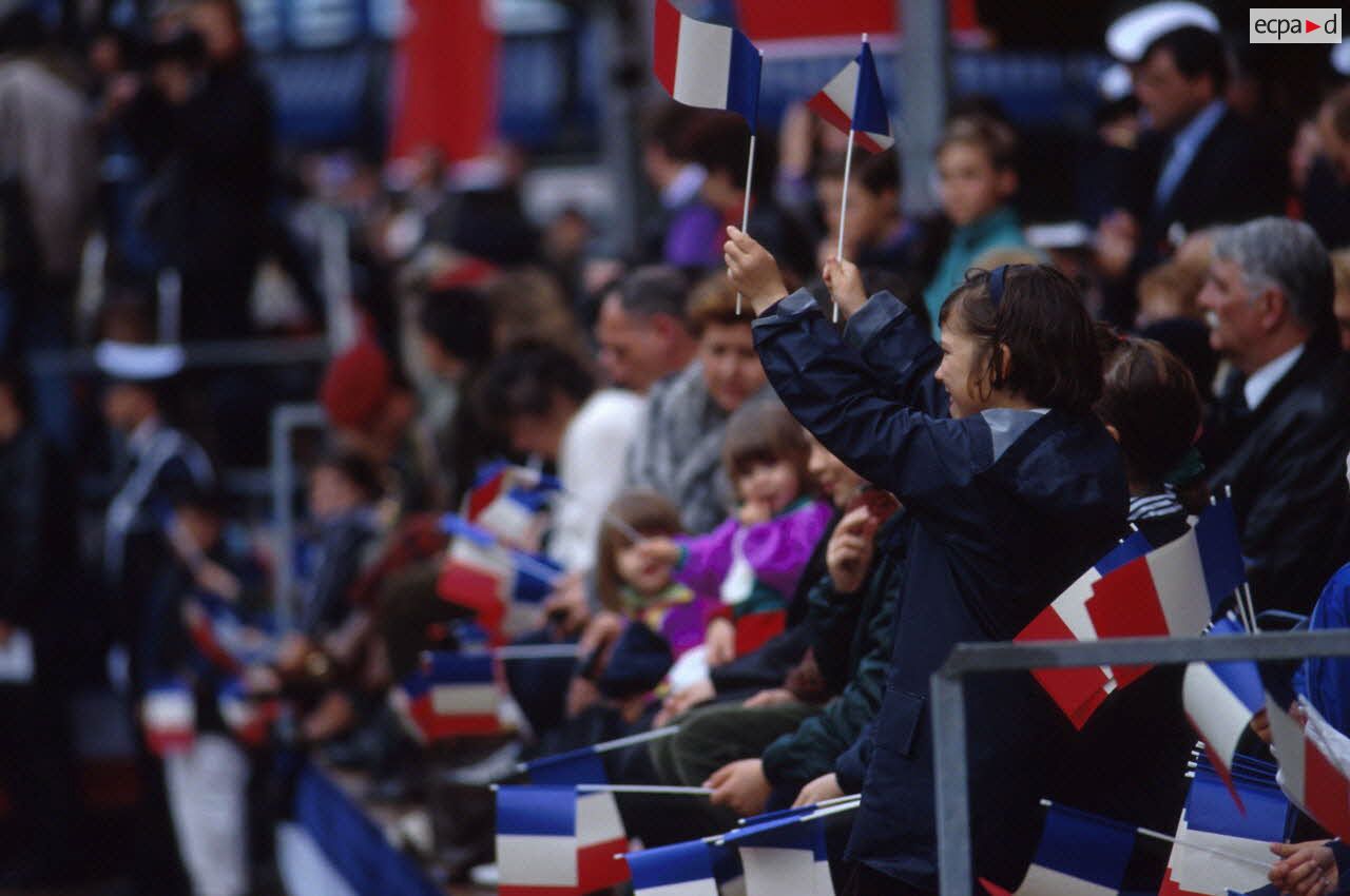 La foule pr&eacute;sente brandit des petits drapeaux fran&ccedil;ais lors du d&eacute;fil&eacute; militaire au retour de la division Daguet &agrave; Toulon.