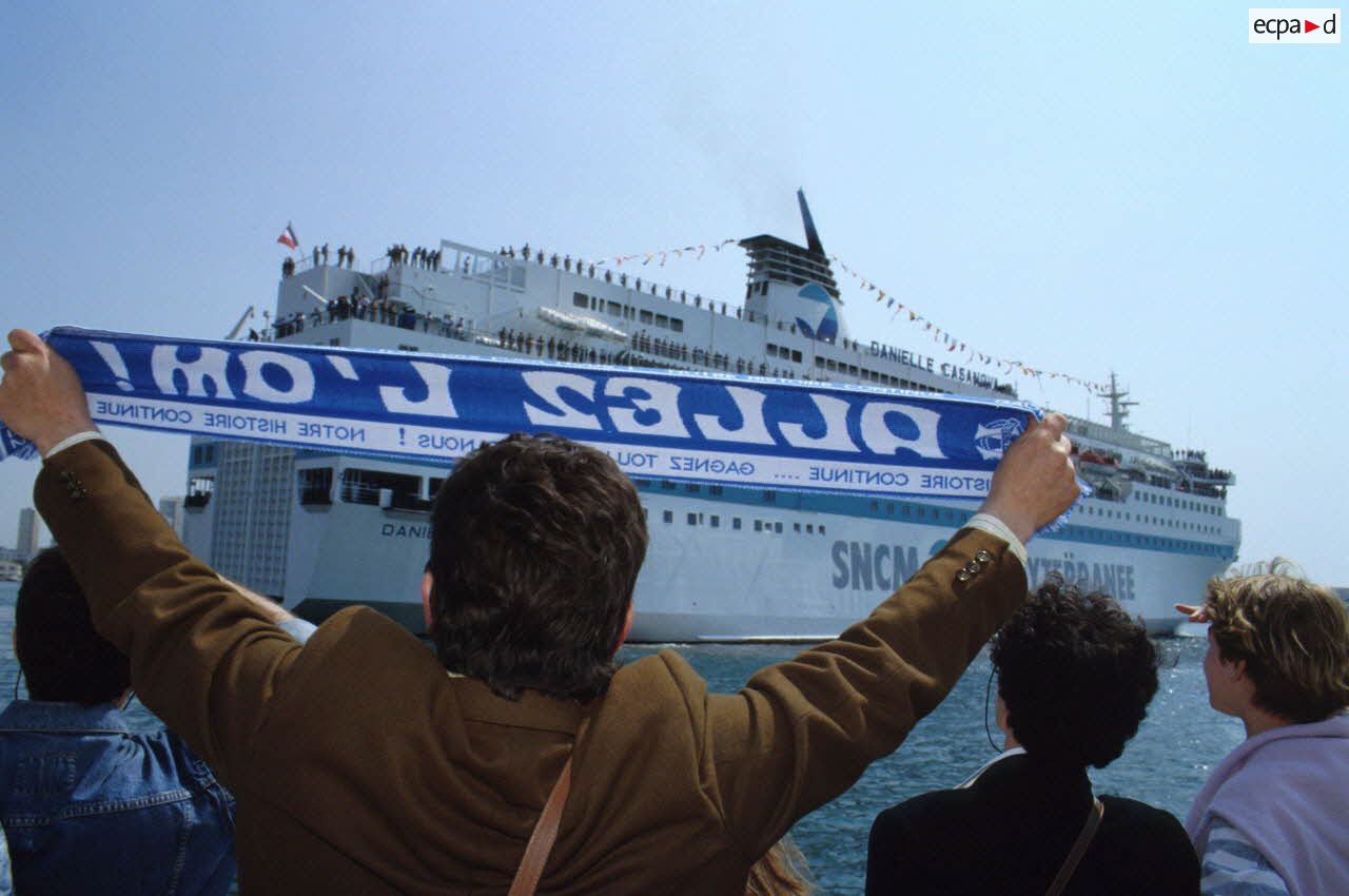 Le ferry affr&eacute;t&eacute; Danielle Casanova accoste au port de Toulon sous le regard des familles en attente sur le quai.