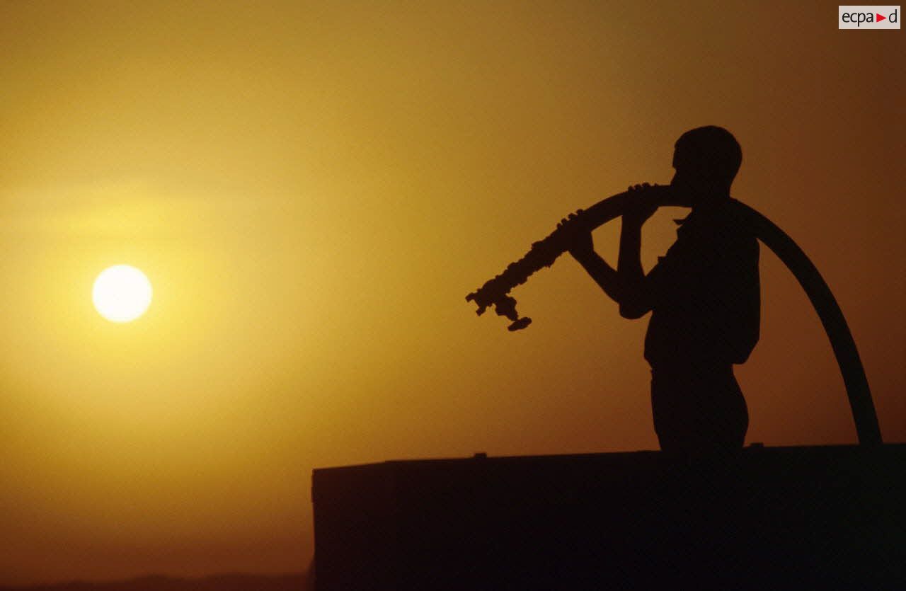 Coucher de soleil sur la station d'épuration et de distribution de l'eau tenue par les éléments du 17e RGP. L'un d'eux remplit une citerne.