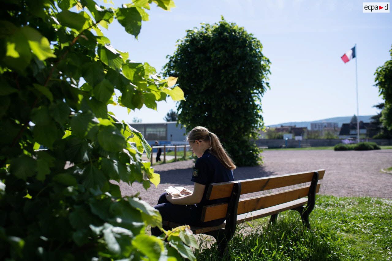 Une collégienne profite de sa récréation pour lire sur un banc dans la cour du lycée militaire d'Autun.