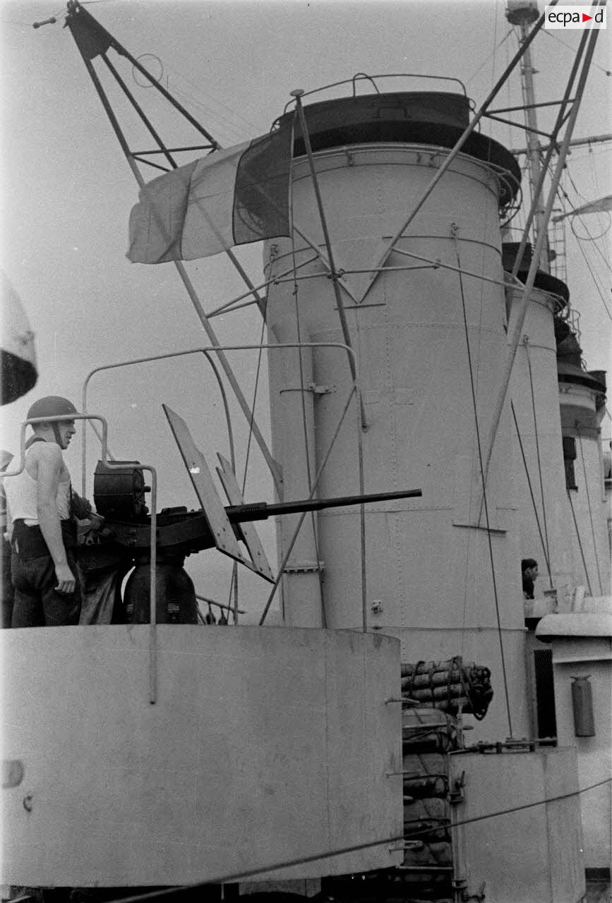 Des marins, servants d'un canon de défense contre-avions (DCA ) sont à leur poste de combat à bord d'un des navires d'escorte du convoi à destination de la Corse.