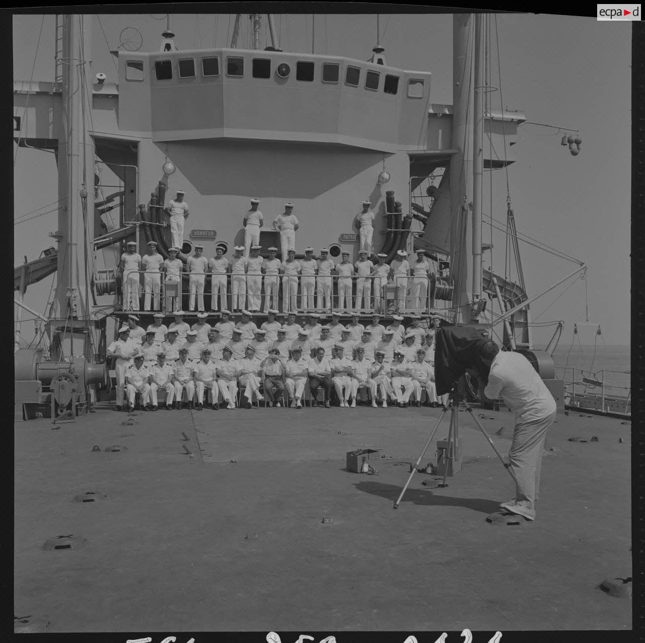 Sur le tournage du film Le jour le plus long. Pour remercier les marins du bâtiment de débarquement de chars (BDC) Argens (L9003), une photographie de groupe leur est offerte par Darryl Zanuck, producteur du film. Ici, le photographe du film, André Berlincourt, pendant la prise de vues.