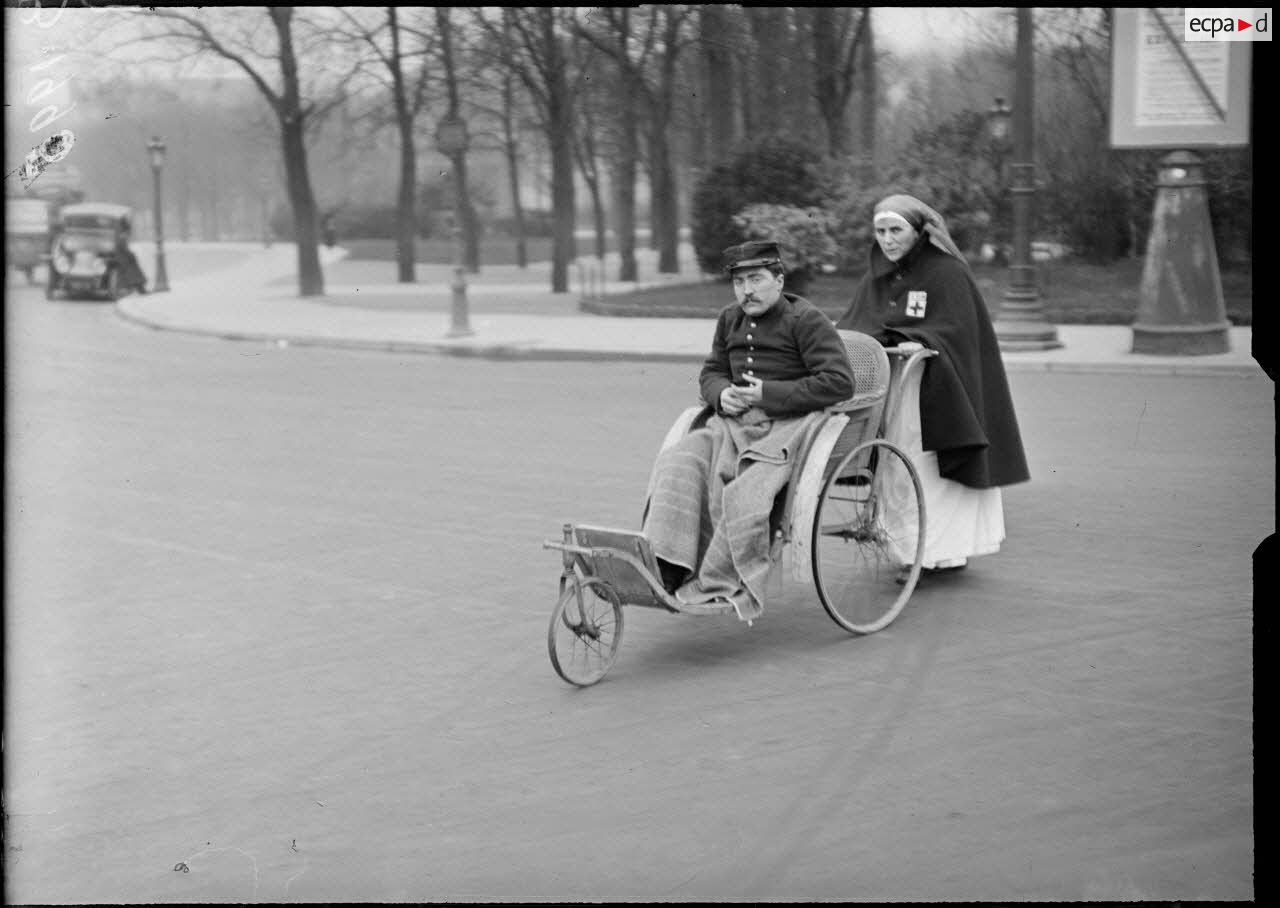 Paris Champs Elys&eacute;es, infirmi&egrave;re promenant un grand bless&eacute;. [l&eacute;gende d&rsquo;origine]