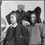 Portrait de jeunes Alsaciennes à l'occasion de Noël dans le village de Masevaux en ruine. A l'arrière plan, le clocher de l'église Saint-Martin.