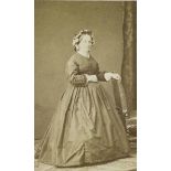 [Portrait d'une femme en pied se tenant à une chaise].