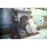 Une femme tire de l'eau au puits devant un tirailleur. [légende d'origine]