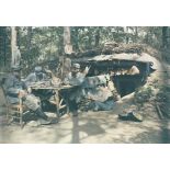 Cantonnement dans les bois : fantassins autour d'une table devant leur abris. [légende d'origine]