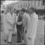 M. Tran Van Huu serre la main d'un civil vietnamien dans une rue d'Hanoï.