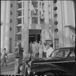 Le général de Linarès et M. Pham Van Binh sortent du bâtiment où a lieu le vernissage de l'exposition 