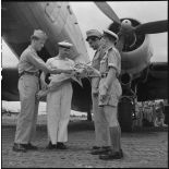 Militaires du rang et officier de l'armée de l'Air regardant un bouquet de fleurs tenu par un marin.