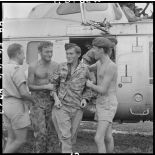 Un infirmier descend d'un hélicoptère sanitaire aidé par ses camarades.