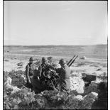 Des artilleurs du 411e RAAA (régiment d'artillerie antiaérienne) servent une mitrailleuse antiaérienne Hochkiss 13,2 mm sur affût bitube.