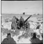 Des artilleurs du 411e RAAA (régiment d'artillerie antiaérienne) servent une mitrailleuse antiaérienne Hochkiss 13,2 mm sur affût bitube.