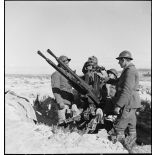 Des artilleurs du 411e RAAA (régiment d'artillerie antiaérienne) servent une mitrailleuse antiaérienne Hochkiss 13,2 mm sur affût bitube avec système de visée Le Prieur-Ricordel.