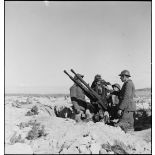 Des artilleurs du 411e RAAA (régiment d'artillerie antiaérienne) servent une mitrailleuse antiaérienne Hochkiss 13,2 mm sur affût bitube.