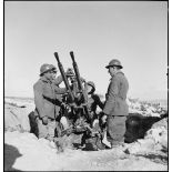 Des artilleurs du 411e RAAA (régiment d'artillerie antiaérienne) servent une mitrailleuse antiaérienne Hochkiss 13,2 mm sur affût bitube.
