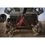 Mise en place du dispositif de levage sur un VAB par des mécaniciens lors d'une intervention technique dans le désert.