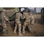 Des mécaniciens changent la roue crevée d'un VAB lors d'une intervention technique dans le désert.