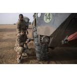 Des mécaniciens changent la roue d'un VAB lors d'une intervention technique dans le désert.