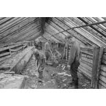 Dans une ferme qui vient d'être réquisitionnée, un caporal-chef (Obergefreiter) surveille des prisonniers de guerre soviétiques.