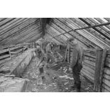 Dans une ferme qui vient d'être réquisitionnée, un caporal-chef (Obergefreiter) surveille des prisonniers de guerre soviétiques.