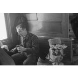 Des permissionnaires à bord d'un train, un sous-officier blessé au visage mange de la saucisse, sur le banc un samovar enveloppé dans du papier journal.