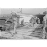 Dans le port de Corfou, déchargement de matériels depuis des péniches de la Kriegsmarine.