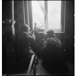 Guetteurs, équipés d'un fusil-mitrailleur FM M-24/29, en position de tir, dans une maison lors de la libération de Mulhouse.