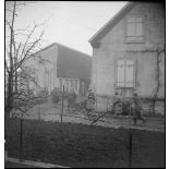 Patrouille de soldats de la 1re DB, équipés de fusils-mitrailleurs, entre les maisons de Mulhouse lors des combats livrés contre les troupes allemandes pour la reconquête de la ville.