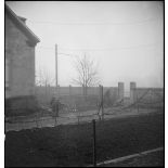 Patrouille de soldats de la 1re DB, équipés de fusils-mitrailleurs, entre les maisons de Mulhouse lors des combats livrés contre les troupes allemandes pour la reconquête de la ville.