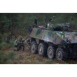 Des légionnaires du 2e régiment étranger d'infanterie (2e REI) progressent à couvert d'un véhicule blindé de combat d'infanterie (VBCI) en forêt de Kadaga, en Lettonie.