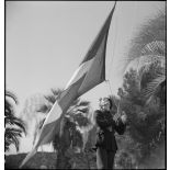 Un chasseur alpin monte les couleurs lors du rassemblement du matin au centre d'hébergement installé dans le Golf Hôtel.