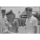 Le général Gracey, en compagnie du général Cogny, sert la main d'un officier.