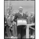 Le maire de Vassieux-en-Vercors présente la croix de la Libération que Georges Bidault, président du Conseil national de la Résistance (CNR), vient de lui remettre à l'occasion de la première commémoration des combats du Vercors.