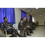 Militaires assistant en retrait au point de situation.