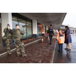 Des soldats sécurisent une zone de colis suspect aux côtés d'agent aéroportuaires à Orly.