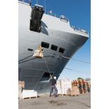 Des marins chargent une palette de fret à bord du bâtiment de projection et de commandement (BPC) Le Tonnerre sur la base navale de Toulon.