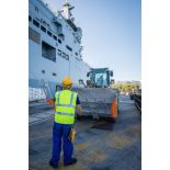 Un marin guide le chargement d'un bulldozer du Génie à bord du bâtiment de projection et de commandement (BPC) Le Tonnerre à Toulon.