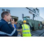 Une enseigne de vaisseau de 1re classe encadre le chargement d'un bulldozer du Génie à bord du bâtiment de projection et de commandement (BPC) Le Tonnerre à Toulon.