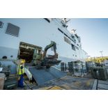 Un marin guide le chargement d'une téléscopelle Pinguely TM 50 du Génie à bord du bâtiment de projection et de commandement (BPC) Le Tonnerre à Toulon.