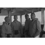 Pierre Messmer, ministre des Armées, Alain Peyrefitte, ministre de la Recherche scientifique et des Questions atomiques et spatiales, et Pierre Billotte, ministre des Départements et territoires d'Outre-mer, en tenue de protection à bord du croiseur de commandement De Grasse lors du déclenchement de l'essai nucléaire Bételgeuse sur l'atoll de Moruroa.