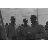 Pierre Messmer, ministre des Armées, Alain Peyrefitte, ministre de la Recherche scientifique et des Questions atomiques et spatiales, et le général de corps aérien Jean Thiry, directeur des centres d'expérimentations nucléaires (DIRCEN), en tenue de protection à bord du croiseur de commandement De Grasse lors du déclenchement de l'essai nucléaire Bételgeuse sur l'atoll de Moruroa.