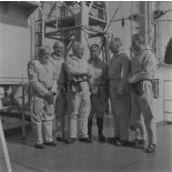 Photographie de groupe des autorités en tenue de protection à bord du croiseur de commandement De Grasse lors du déclenchement de l'essai nucléaire Bételgeuse sur l'atoll de Moruroa.