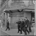 Robert Lacoste, ministre de l'Algérie, et sa délégation dans les rues d'Alger, devant le bâtiment Air Algérie.
